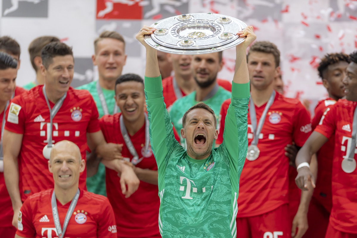 Manuel Neuer hebt die Meisterschale bei der Siegerehrung, Mannschaft im Hintergrund